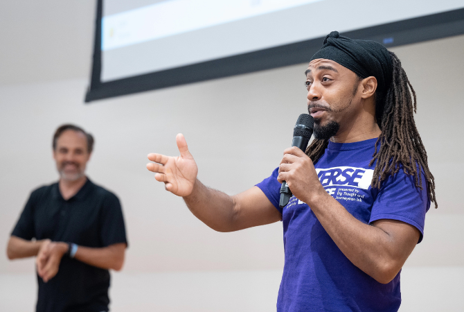 man speaking holding mic