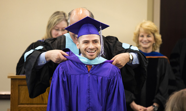 TCU student at a College of Education Master’s hooding ceremony