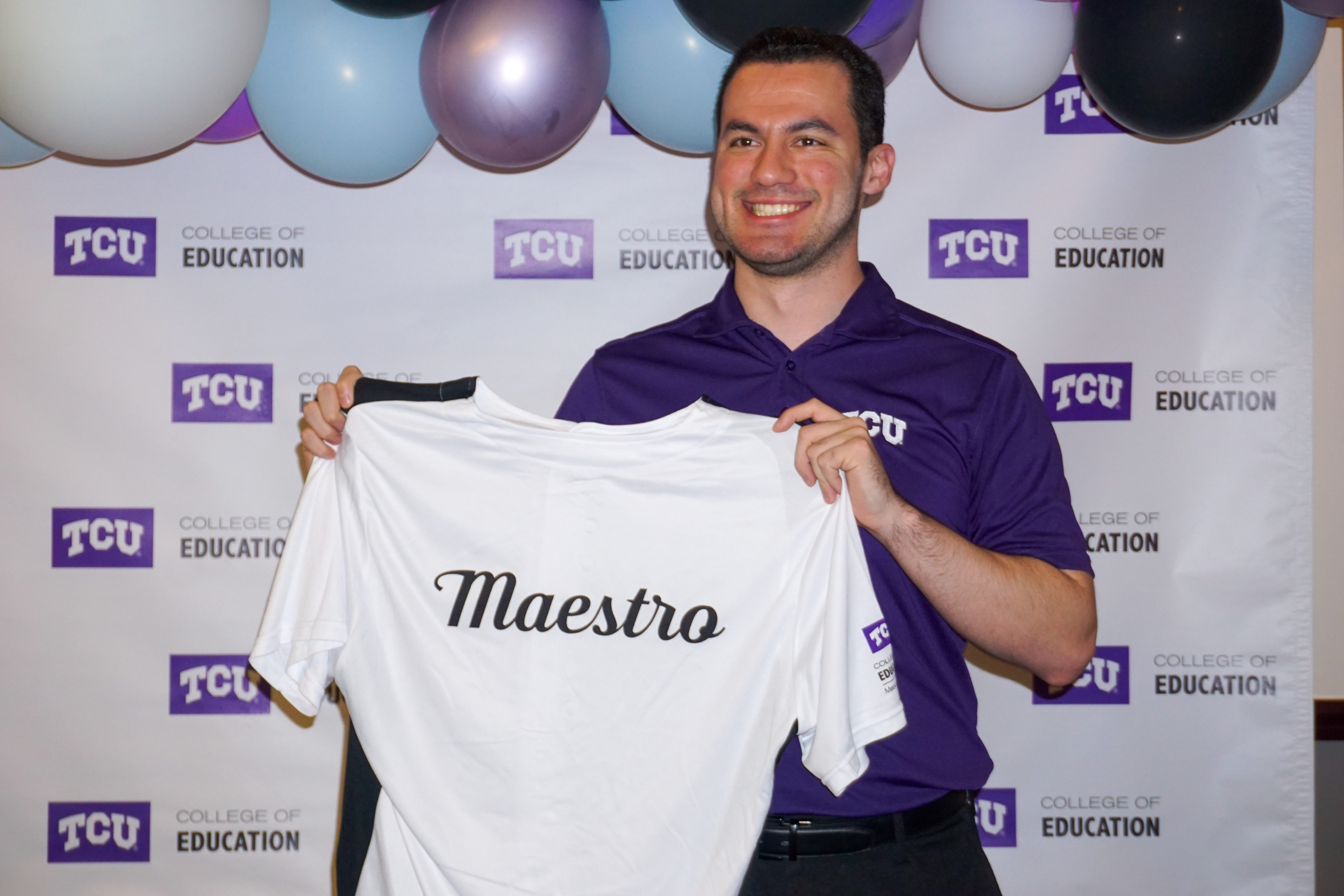 Male smiling with jersey with "maestro" on back