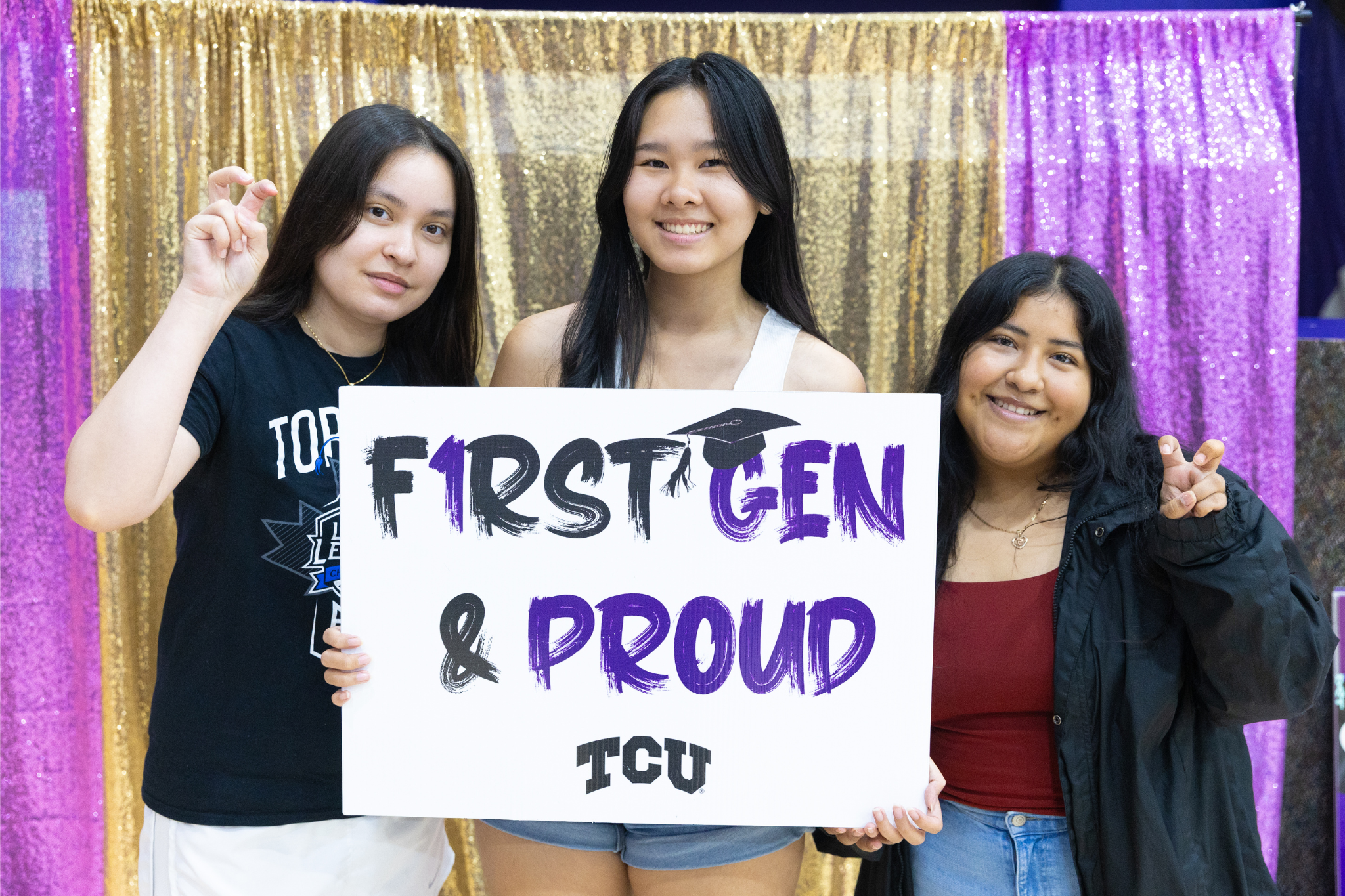 3 female students with "first gen & proud" sign