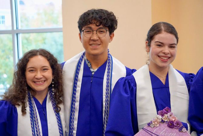 graduates in cap and gown smiling