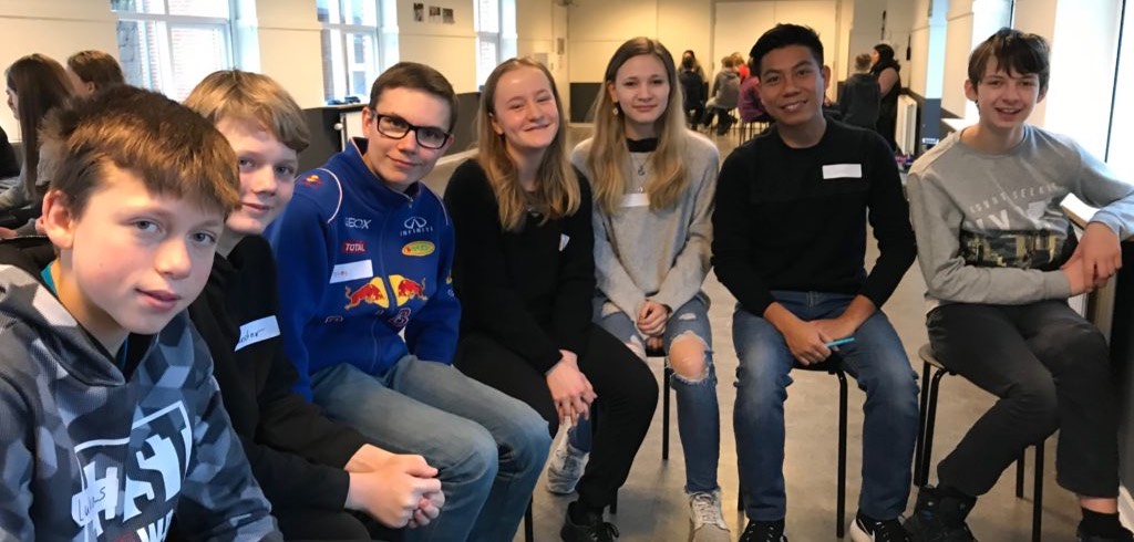 James Sang sits with a group of students while teaching in Denmark
